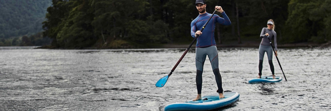 Man and woman on a paddle with long-sleeved t-shirt and UV-protective pants