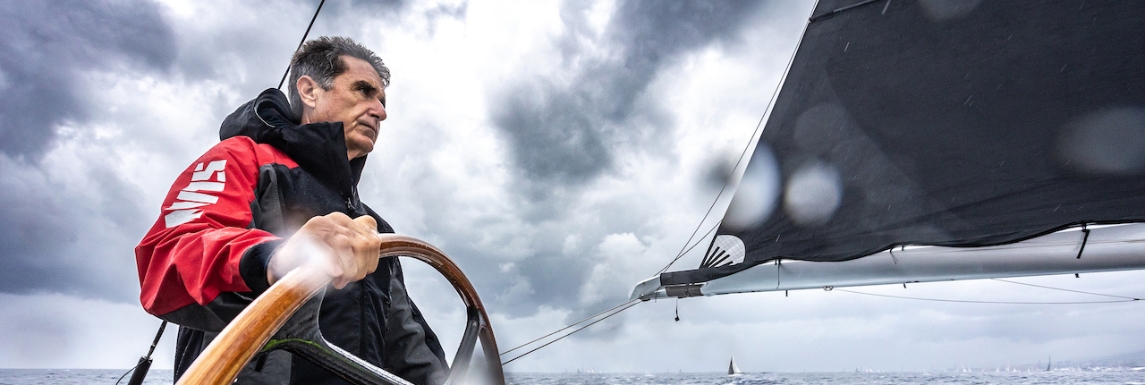 Sailor at the helm of his boat with Slam sailing jacket