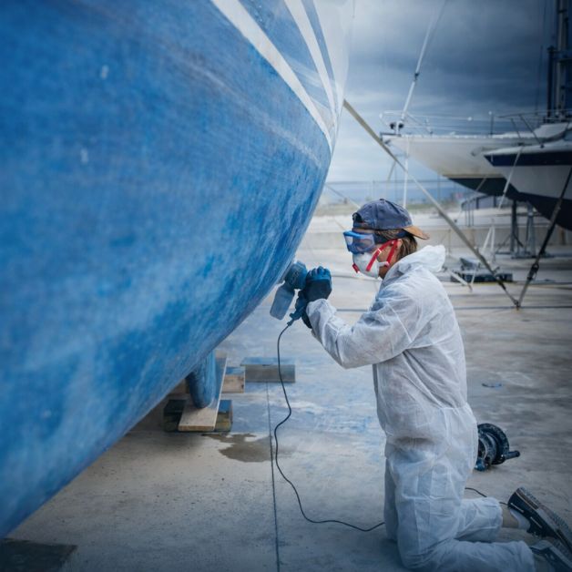 homme qui prépare un antifouling bateau