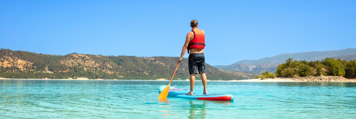 homme avec un gilet de flottaison sur sa tenue paddle