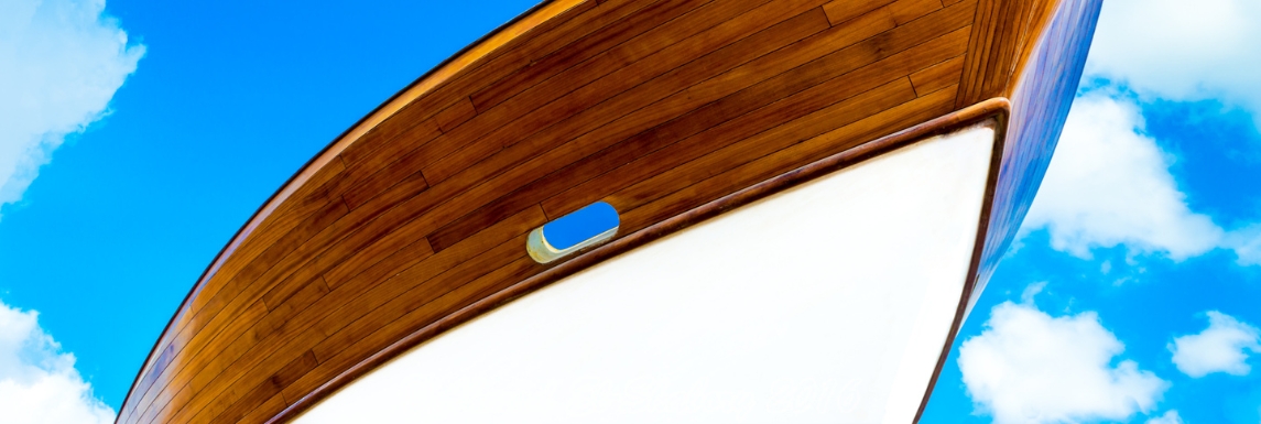 Casco de barco marrom envernizado sob um céu azul