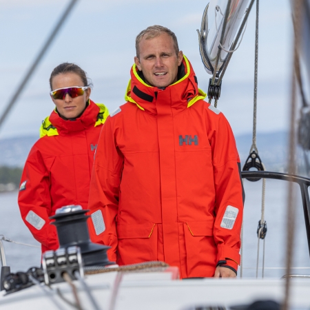 Marinheiros ao leme com coletes de navega&ccedil;&atilde;o Helly Hansen